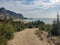 Blonde sport woman in sportwear running on mountain path. Summer vacations in Greece