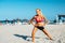 Blonde sportswoman stretching on beach