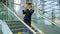 Blonde stewardess standing on stairs making toy paper plane in hall
