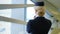 Blonde stewardess standing in waiting room wearing hat uniform