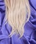 Blonde straight hair on blue silk fabric