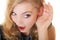 Blonde surprised gossip girl with hand behind ear listening secret