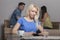 Blonde with tablet sitting in cafeteria