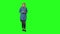 Blonde teenager girl calmly walking and reading text message on her mobile phone on green screen. Front view.