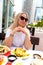 A blonde tourist girl in the Dubai resort area stops to cape some memories with selfies against the stunning backdrop of