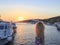 Blonde watching sunset in the new port of Mykonos in Mykonos, Gr