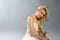 Blonde in white dress holding golden calla lilly