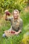 Blonde winegrower handing a red grape