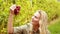 Blonde winegrower handing a red grape