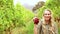 Blonde winegrower handing a red grape