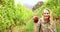 Blonde winegrower handing a red grape