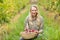 Blonde winegrower holding a red grapes basket