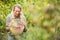 Blonde winegrower looking at a red grapes basket