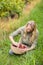 Blonde winegrower looking at a red grapes basket