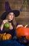 Blonde witch with a broom and pumpkins for Halloween