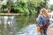 A blonde woman admires the stillness of a beautiful jetty of a small river