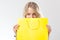 Blonde woman behind yellow shopping bag