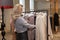 Blonde woman chooses beautiful clothes in a boutique. Shopping and love at home