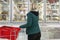 Blonde woman chooses products in the freezing department in a supermarket. Healthy eating Back view