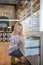 Blonde woman crouching, opening drawer, looking inside