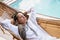 Blonde woman with dreadlocks sleeping in a woven hammock