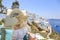 Blonde woman enjoying the view of greek town Thira in Santorini, Greece