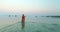 Blonde woman entering into sea at Slatinica beach, Croatia