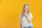 Blonde woman gesturing hush to be quiet. Secret concept. Beautiful caucasian woman with kanekalons isolated on yellow background