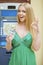 Blonde woman in a green dress is holding a cash dollars