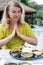 Blonde woman greeting Namaste before the meal in Indian restaurant, dal bhat served