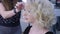 Blonde woman with a haircut at a session with a hair stylist. Glamorous styling with curls,