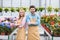 Blonde woman and handsome man in aprons among flowers