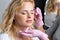 Blonde woman having permanent make-up tattoo on her eyebrows. Closeup beautician doing tattooing eyebrow.Professional makeup and