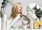 Blonde woman healthy silky skin sits at table with cosmetics means applying statue head facial mask with brush