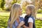 Blonde woman and her young daughter in a park side view