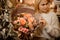 Blonde woman holding bouquet of roses decorated with berries and gilded cones