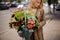 Blonde woman holding a lovely wicker basket of flowers against t