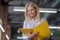 Blonde woman holding yellow folder, reading, smiling