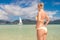 Blonde woman looking at a sail boat
