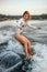 Blonde woman masterfully rides the wave on surfboard