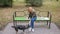 Blonde Woman in a park feeding a stray mongrel dog