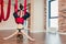 Blonde woman practices inversion anti-gravity yoga position, hanging upside down