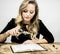 Blonde woman reading the bible with a magnifier against a white background