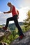 Blonde woman in red climbing boots walking on the mountains