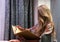 Blonde woman sitting on a chair reading a book