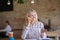 Blonde woman sitting at desk, having phone conversation, smiling