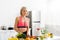 Blonde woman in sportswear cutting cherry tomatoes in kitchen