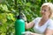 Blonde woman spraying vineyard outdoors