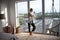 Blonde woman standing near window in living room