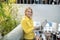 Blonde woman standing on stair landing, holding laptop, typing, smiling